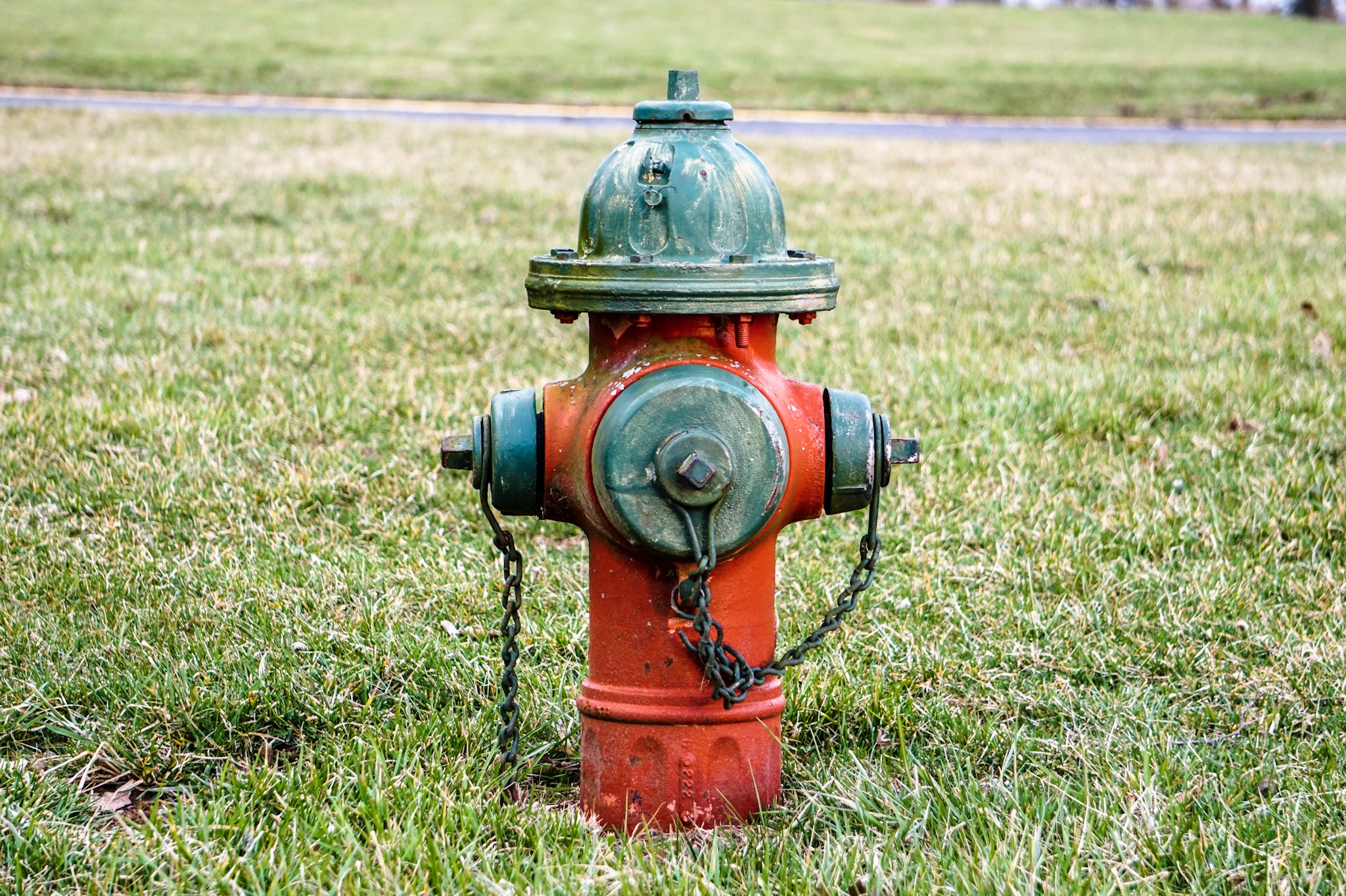 An old red fire hydrant spotted with rust and age.