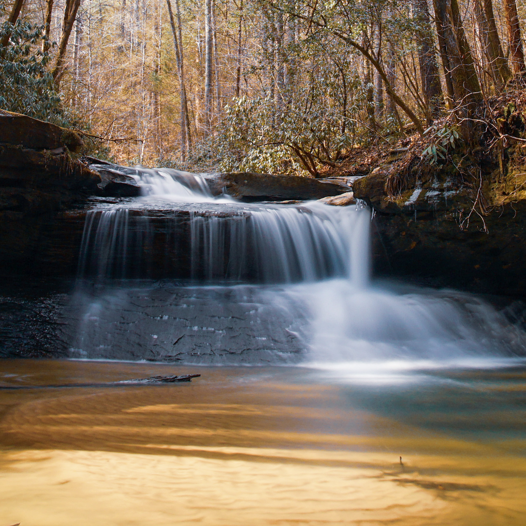 Long-exposure waterfall on Swift Camp Creek, moss-covered sandstone and bare winter canopy above.
